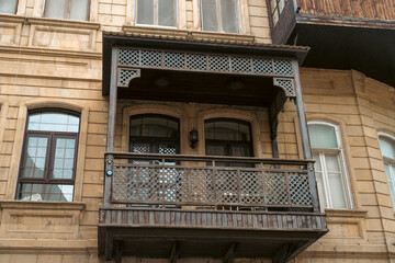 A balcony with a railing and a chair on it. The balcony is on the side of a building