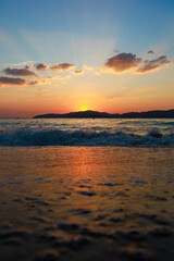 Fototapeta premium Picture of the beach at sunset with the foreground being a sandy beach and sea water. The background is Khram Yai Island. The name of the beach is Haad So, Chonburi Province, Sattahip District.