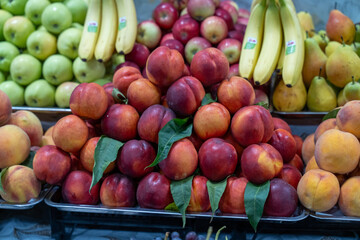 A pile of red apples and bananas. The apples are piled on top of each other and the bananas are on the bottom