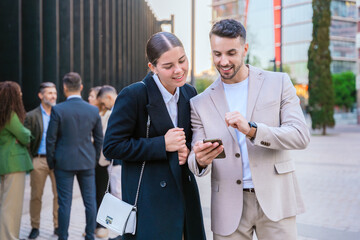 Colleagues Smiling and Sharing Ideas on a Smartphone Outdoors