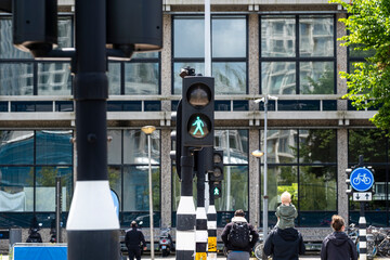 A vibrant green pedestrian signal illuminates a city street, highlighting urban infrastructure and the importance of pedestrian safety in modern city planning.