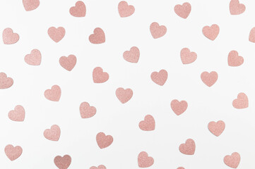 Top view of pink glitter hearts on white background. Valentine's day, pink glitter hearts, love wallpaper. Flat lay, copy space.