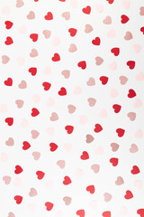 Top view of colorful hearts on white background. Pink glitter hearts, red hearts, pink hearts. Valentine's day, love wallpaper. Flat lay, copy space.