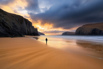Fototapeta premium mysterious figure walking alone on a desolate beach at sunset