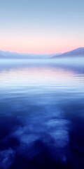 Obraz premium Serene sunrise over calm lake reflecting pastel sky.