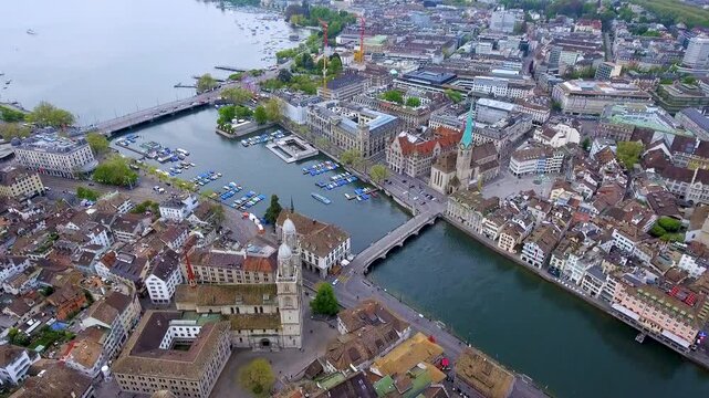 Stunning aerial footage of Zurich's historic Old Town, showcasing iconic churches, bridges, and vibrant Lake Zurich. A picturesque blend of urban beauty and natural charm.