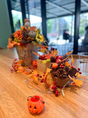 Festive autumn table arrangement with vibrant fall decorations and a miniature pumpkin. Warm tones and cozy ambiance evoke the spirit of the harvest season and Halloween celebrations
