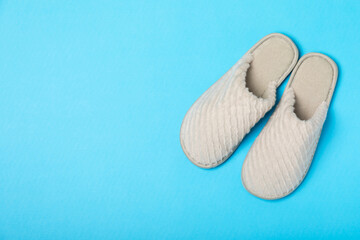 Soft slippers on a bright colored background, close-up. House slippers. Comfortable shoes for home. Foot care concept. Home comfort. Space for text. Copy space.