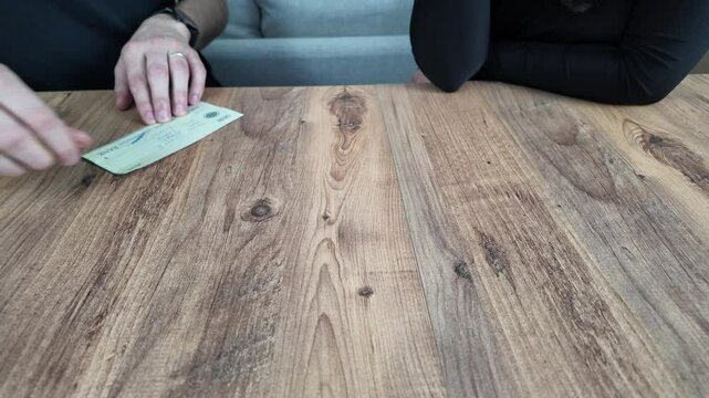 man writes a cheque to a woman for his debt.