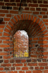 Fototapeta premium Small grated window in the thick brick wall surrounding Frederiksborg Castle