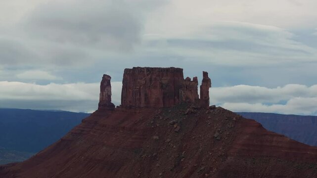 A stunning mesa formation in Moab with dramatic cloudy skies, showcasing solitude