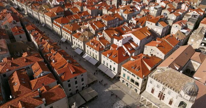 Dubrovnik's old town with orange rooftops and a lively main street, aerial view
