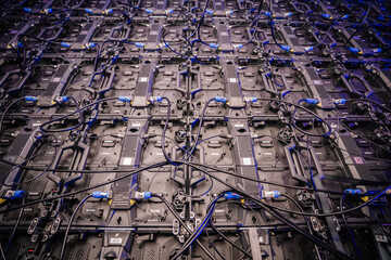 Detailed view of the back of a large LED screen with interconnected cables, wiring, and electronic...