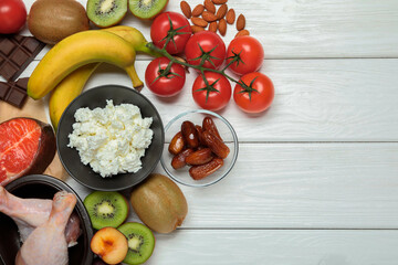 Different fresh products rich in serotonin on white wooden table, flat lay. Space for text