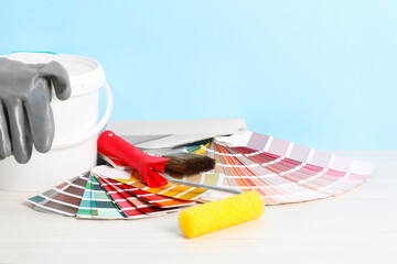 Different painter's tools on white wooden table, space for text. Decorating and design © New Africa