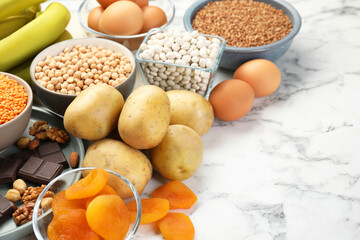 Different products rich in iron on white marble table, space for text. Anemia diet plan