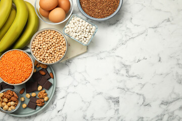 Different products rich in iron on white marble table, flat lay with space for text. Anemia diet plan