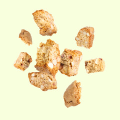 Tasty cookies with almond nuts in air on pastel green background. Traditional Italian Cantuccini