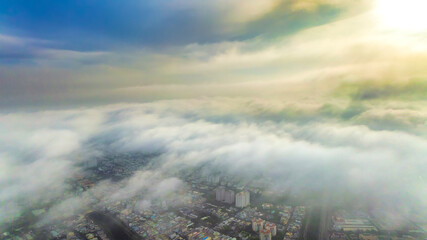 Fototapeta premium Aerial view of Saigon cityscape at morning with misty sky in Southern Vietnam. Urban development texture, transport infrastructure and green parks