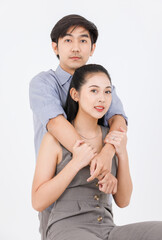 Fototapeta premium Portrait of young asian happy attractive cheerful couple love, Joyful sweethearts hugging embracing cuddle enjoy good time romantic date, posing to camera smiling sitting together on white background