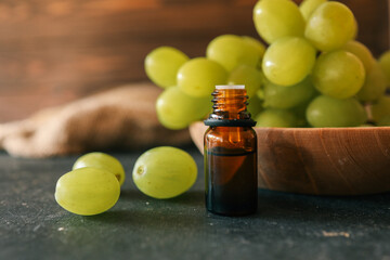 Amber glass bottle with green grapes in the background, representing natural skincare or essential oil products. Warm and organic setting