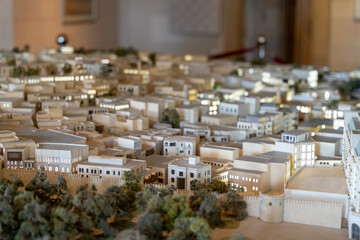 A model of a city with a large building in the center. The city is made of white material and has a lot of detail