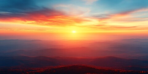 Fototapeta premium Vibrant sunset over hazy mountain range.