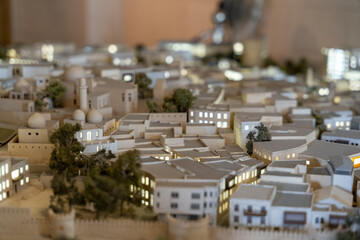 A model of a city with a lot of buildings and a small tree. The buildings are all white and the tree is in the middle of the scene