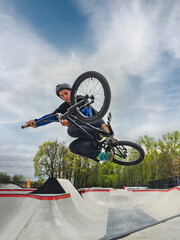 BMX bicycle rider doing stunt Tabletop. Skilled BMX freestyler athlete jumping and doing aerial...