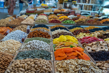 A large variety of nuts and dried fruits are on display. The scene is colorful and inviting, with a sense of abundance and variety
