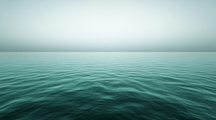 Obraz premium Smooth turquoise waves undulate under a calm sky at dawn