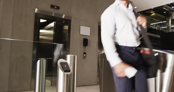 Turnstile gate with card reader controlling access in modern office building