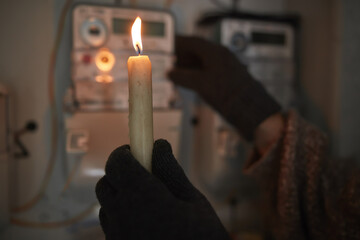 Checking the electricity power meter with a candle in cold winte