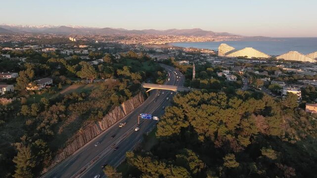 Freeway with view of the sea and Alps mountains during sunset, aerial video, Antibes, France, 4K