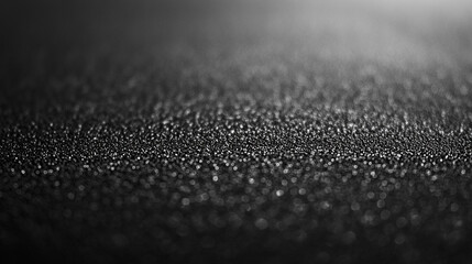 Texture of fine black sand with glittering particles under soft light