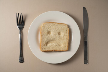Gluten allergy, one slice of fresh toast bread with sad face. Gluten free food.