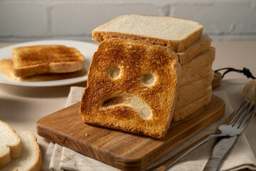Gluten food, slice of toasted bread with sad face. Gluten allergy