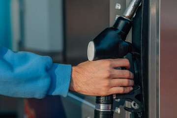 hand at the gas pump at the gas station
