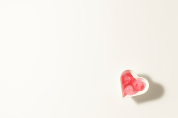 Valentines Day minimal background. White background wih heart shaped pink ice