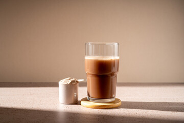 Protein shake and chocolate protein powder in a scoop, food supplement
