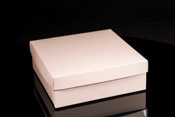 Package box rectangle, blank advertise template for products packaging. White color empty closed cardboard container against black background