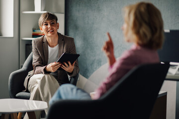 Businesswomen using tablet and discussing during business meeting in office