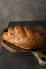 Freshly baked bread with seeds on grey table, closeup
