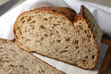 Cut loaf of fresh bread on table, closeup