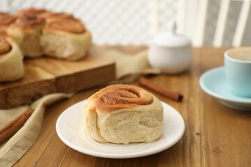 Freshly baked cinnamon roll on wooden table, closeup