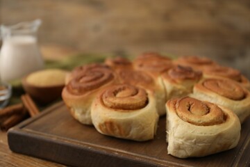 Freshly baked cinnamon rolls on wooden table, closeup