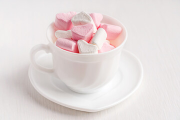 Cup of morning cocoa or coffee with topping of fluffy sweet marshmallow heart shaped dessert snack...