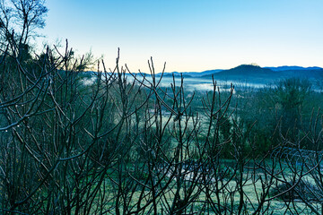 Misty winter morning landscape with fog on the hills of the Ariege region in France. Idyllic landscape