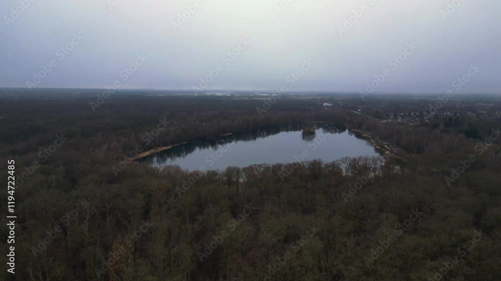 Poster Drone shot overlooking Lake surrounded by trees and reflecting cloudy sky in Germany. Best aerial view flight panorama overview drone