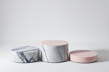 Three marble pedestals, one with blue marbling and two with pink tops